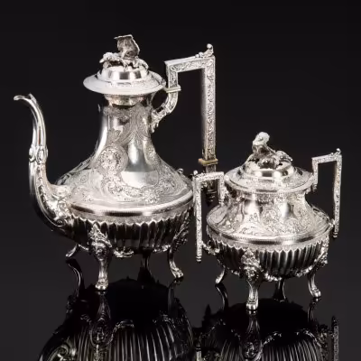 купить Кофейник и сахарница, украшенные маскаронами, цветочными гирляндами и фигурными хватками в виле соцветий, металл, серебрение, гравировка, канфарение, рог, Западная Европа, 1920-1950 гг.