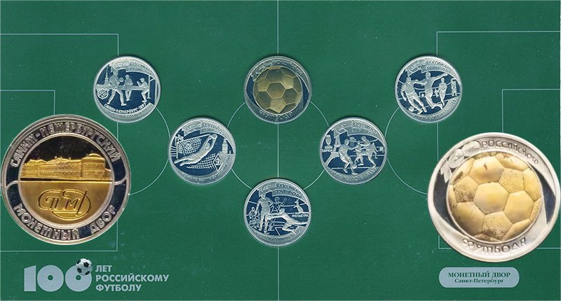 Жетон крупным планом на фоне главного разворота буклета с монетами