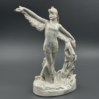 женщина держит в руках маленькую фарфоровую фигурку аиста